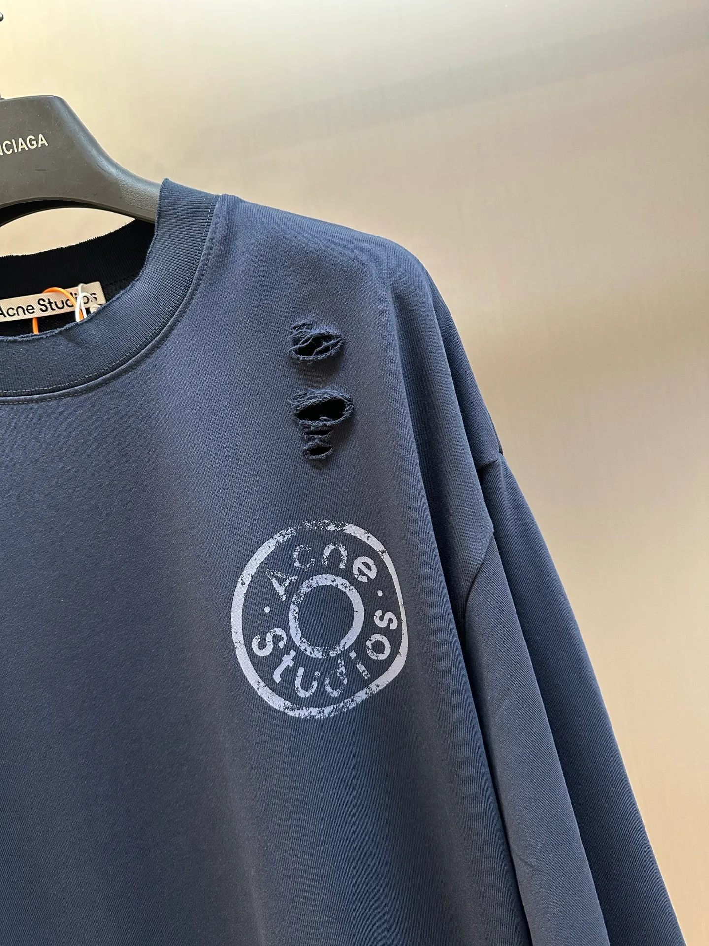 Ac Studios distressed logo sweatshirt Customized etched soft-extract raw cotton fleece, deep dark blue is quiet and restrained, matte fog base color, symbiotic with the destructive texture, Retro pioneer style, denim rivet style logo printing on the chest, replica of the old steel seal embossed texture, the color will naturally fade with the washing of the garment, and the whole body will be more Artificially torn holes are carefully arranged, and the raw edges of the rips are stretched out wantonly, replicating the wear and tear traces eroded by time, destroying and deconstructing the regular shackles of standard clothing, integrating decadent street aesthetics and Nordic minimalist design genes, creating a pioneering ready-to-wear product with outstanding character. Glue printing is used. The chest printing is modified by the film screen three times. The glue liquid paint is used to print the pattern on the fabric, and the fabric is baked to fix the printed pattern. Many parts of the body of the garment are worn and worn at regular intervals, with manual brush marks added to add texture and depth to the surface of the garment to imitate the texture of natural wear and tear size: s m l xl
